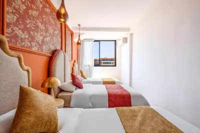 a hotel room with two beds and a window at LE MAJOREL Centre Marrakech in Marrakech