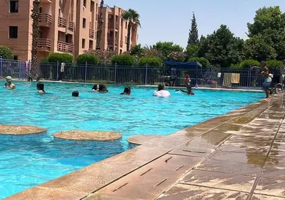 a group of people swimming in a swimming pool at Appart Nour in Marrakech