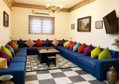 a room with a blue couch with colorful pillows at Appart Nour in Marrakech
