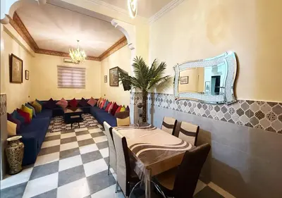 a restaurant with a table and a mirror and couches at Appart Nour in Marrakech