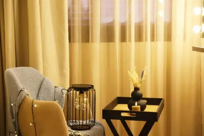 a room with a chair and a table with a vase at Charming apartment in a tourist village Premium village in Marrakech