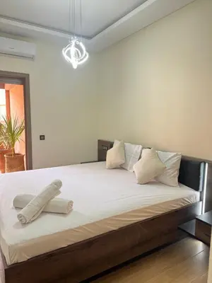 a bedroom with a large bed with white sheets at Luxuriöse Wohnung mit Pool und Netflix in Marrakech