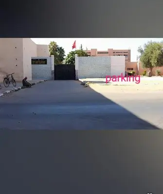 a person sitting in front of a building with a parking sign at Étoile de fatima - au cœur de la médina in Marrakech