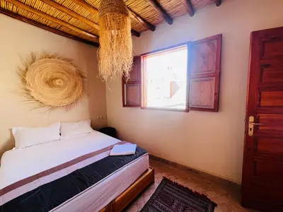 a bedroom with a bed and a window at Riad Émeraude Privé 3 chambres avec piscine Médina Marrakech in Marrakech