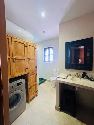 a bathroom with a sink and a washing machine at Riad Émeraude Privé 3 chambres avec piscine Médina Marrakech in Marrakech