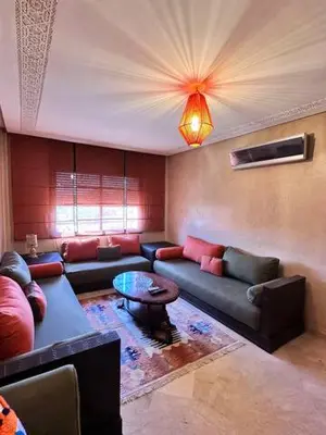 a living room with a couch and a table at Central Gueliz Apartment Bright & Peaceful in Marrakech
