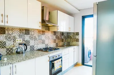 a kitchen with white cabinets and a stove top oven at Chic Marrakech Getaway with Pool, Gym & Security in Marrakech