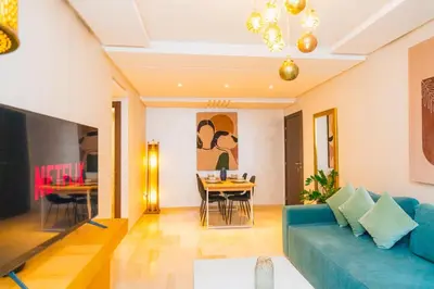 a living room with a blue couch and a table at Chic Marrakech Getaway with Pool, Gym & Security in Marrakech