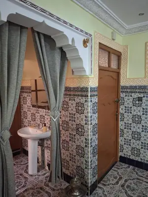 a bathroom with a sink and a shower with curtains at Lalla Fatima - a deux pas de la Bahia in Marrakech