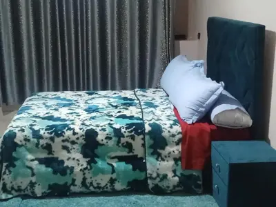 a bedroom with a bed with a blanket and a chair at appartement marrakech Gueliz in Marrakech