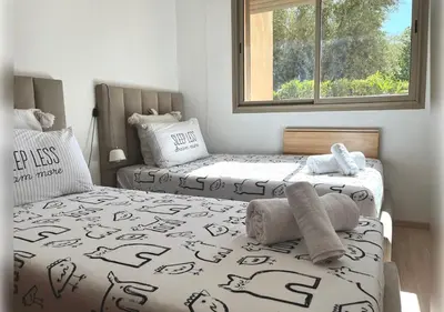 two twin beds in a bedroom with a window at Ehden Properties - Appt d'exception dans l'incontournable Prestigia in Marrakech