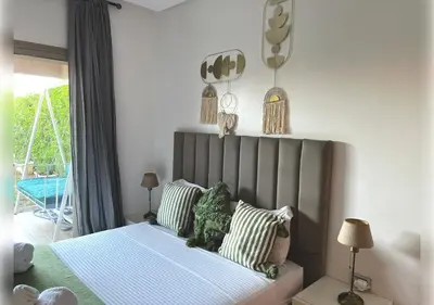 a bedroom with a bed with a teddy bear on it at Ehden Properties - Appt d'exception dans l'incontournable Prestigia in Marrakech