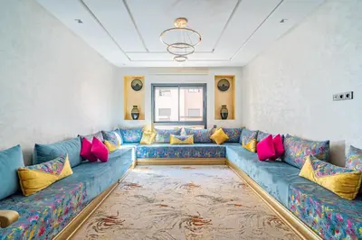a living room with a blue couch with colorful pillows at 5 Star City Oasis Modern and Cozy in Marrakech
