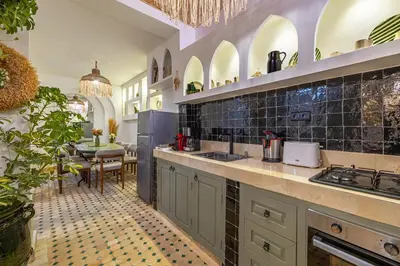 a kitchen with a counter and a dining room at Riad Dar Mimouna -Exclusive&Brand new -Pool- 8pax in Marrakech