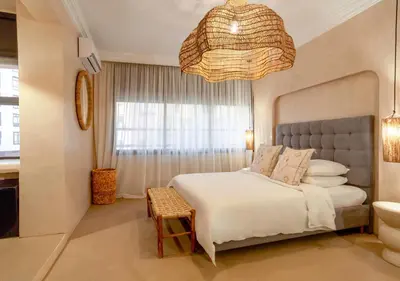 a bedroom with a large bed and a chandelier at Apartment in Gueliz, Riad style, equipped and central in Marrakech