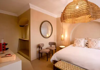 a bedroom with a bed and a mirror and chairs at Appartement à Guéliz, style Riad, équipé & central in Marrakech