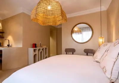 a bedroom with a white bed and a mirror at Appartement à Guéliz, style Riad, équipé & central in Marrakech