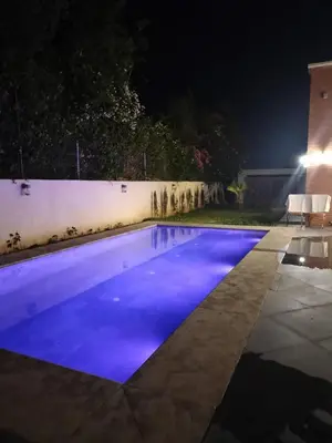 a swimming pool at night with blue illumination at Villa Moderne 5 chambres vue sur Atlas in Marrakech