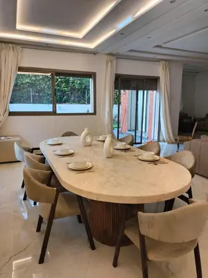 a dining room with a large wooden table and chairs at Villa Moderne 5 chambres vue sur Atlas in Marrakech