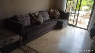 a living room with a couch with pillows on it at A Cosy Maison avec un accès direct à la piscine in Marrakech