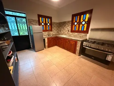 a kitchen with a stainless steel refrigerator and stained glass windows at DAR ENNAGA - Havre de paix, avec piscine chauffée , à 10 minutes de Marrakech in Marrakech