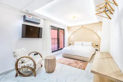 a bedroom with a bed and a flat screen tv at Duplex Confort, Jacuzzi à 5min de Majorelle&Médina in Marrakech
