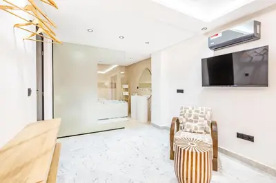 a living room with a tv and a chair at Duplex Confort, Jacuzzi à 5min de Majorelle&Médina in Marrakech