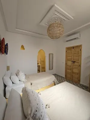 a room with three beds and a couch in it at Dar laarbi Kasbah in Marrakech