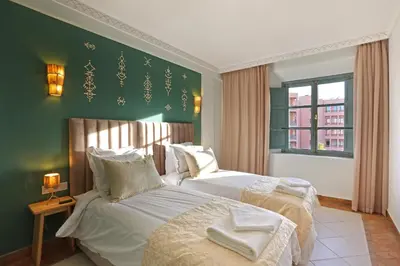 a bedroom with two beds and a green wall at Spacious 3Br Apartment-Pool&AC- Heart of Marrakech- Hivernage in Marrakech