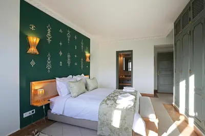 a bedroom with a bed and a green wall at Spacious 3Br Apartment-Pool&AC- Heart of Marrakech- Hivernage in Marrakech