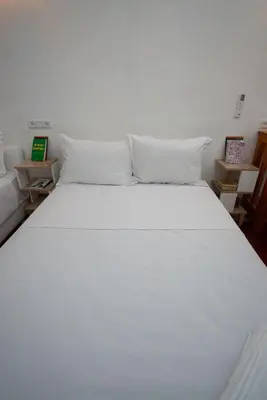 a white bed with white pillows in a room at Studio Blue Majorelle Marrakech in Marrakech