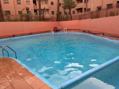 a large swimming pool with blue water in a building at Marrakech Sakan Annakhil im6 n31 in Marrakech
