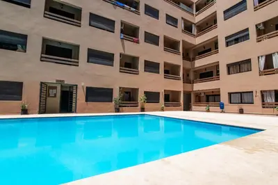 an empty swimming pool in front of a building at Gueliz Train Station - Swimming Pool - Cosy in Marrakech