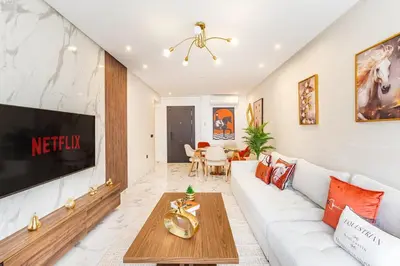 a living room with a white couch and a tv at Luxury House avec Piscine et Terrasse in Marrakech