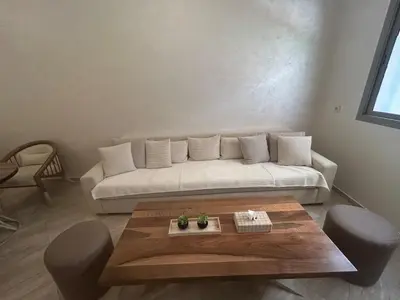 a living room with a white couch and a table at Appartement Haut Standing in Marrakech