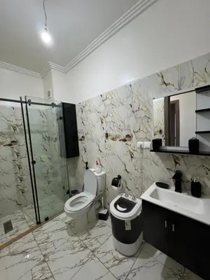 a bathroom with a toilet and a shower and a sink at Jardin chrifiya in Marrakech