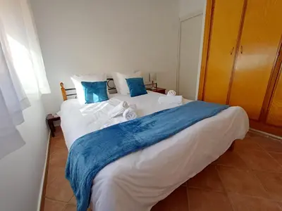 a bedroom with a large bed with blue and white sheets at Gueliz Appartement in Marrakech
