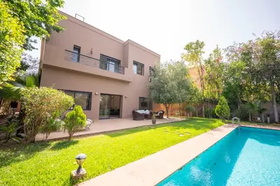 a house with a swimming pool in front of a yard at Villa Jnan Targa Pool & Garden in Marrakech