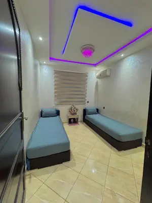 a room with two beds and a ceiling with purple lights at Marrakech in Marrakech
