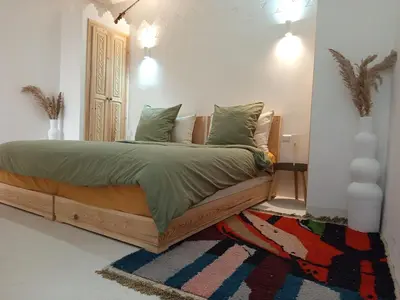 a bedroom with a wooden bed with a rug at Minka Marishan exclusif Riad in Royal destrict in Marrakech