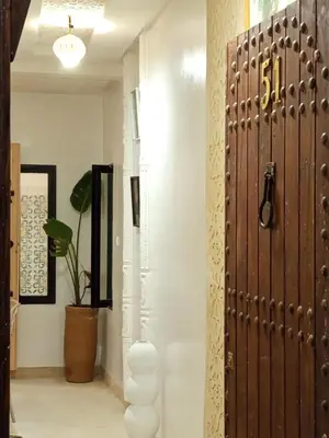 a hallway with a wooden door and a potted plant at Minka Marishan exclusif Riad in Royal destrict in Marrakech