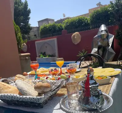 a table with food and glasses of wine on it at Riad dar Nafaa in Marrakech