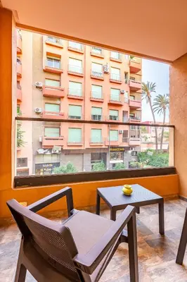 a room with a chair and a table and a large window at Central Gueliz 1-bedroom apartment in Marrakech