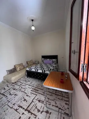 a living room with a bed and a table at Dar El Bahja à 5 minutes de la place Jemaa el-Fna in Marrakech