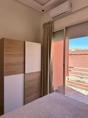 a bedroom with a bed and a large window at Studio Cosy Proximité Confort in Marrakech
