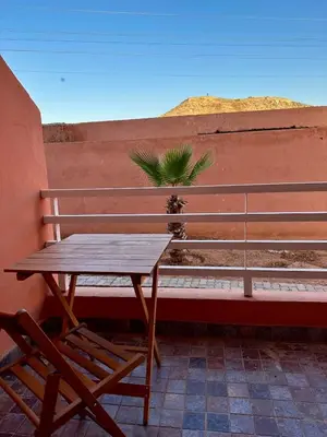 a wooden bench and a wooden table and a plant at Studio Cosy Proximité Confort in Marrakech