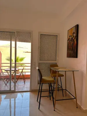 a dining room with a table and chairs and a patio at Studio Cosy Proximité Confort in Marrakech