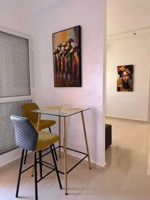 a table and chairs in a room with a painting at Studio Cosy Proximité Confort in Marrakech