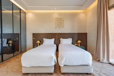 two beds in a hotel room with mirrors at Villa Nabil by TheCasaEdition Cinema, Heated pool & Jaccuzi in Marrakech