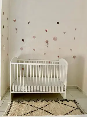 a white crib in a room with hearts on the wall at Cosy appartement near to airport in Marrakech